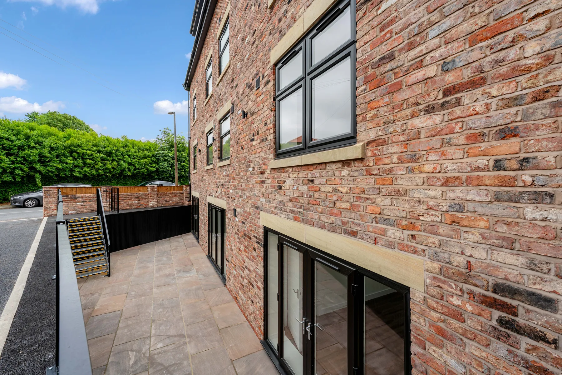 Dark-framed replacement windows fitted into traditional brickwork